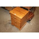 A modern pine three drawer bedside chest