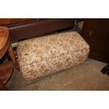 A floral upholstered ottoman