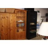 A pine open fronted bookcase raised on cupboard ba