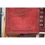 An approx. 2'10" x 2' red patterned rug; together