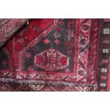 An approx. 5'5" x 4'1" red patterned rug