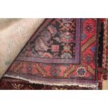 An approx. 6'7" x 3'9" red and blue patterned rug