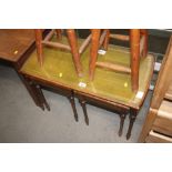 A nest of three leather topped occasional tables