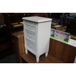A white painted bedside chest fitted three drawers
