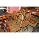 A set of four stick and wheel back dining chairs;