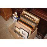 A box of various framed prints