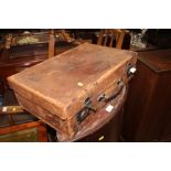 A brown leather suitcase containing two editions o