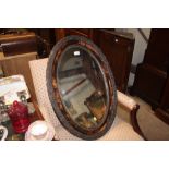 A mahogany oval and bevel edged mirror
