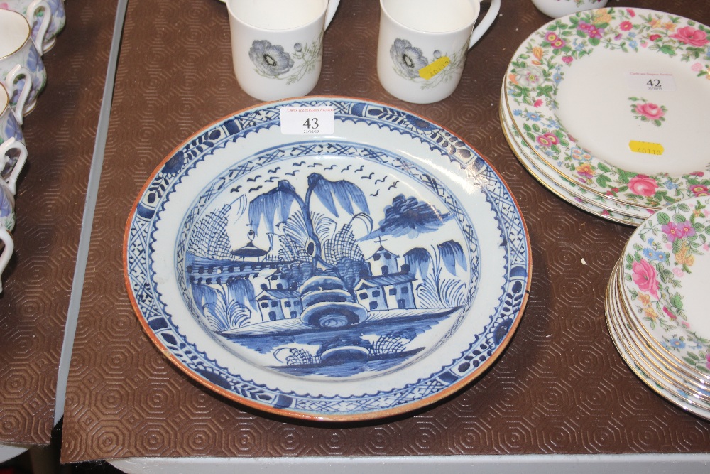 An antique shallow delft dish decorated with houses