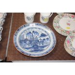 An antique shallow delft dish decorated with houses