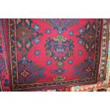 An approx. 5'6" x 3'9" red floral patterned rug
