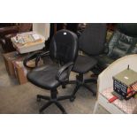 A black leather upholstered swivel office chair; t