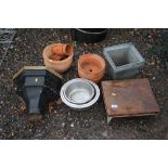 A cast iron rain hopper; dog bowls; terracotta pla