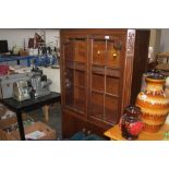 An oak bookcase raised on cupboard base