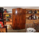 A walnut veneered bow fronted wardrobe