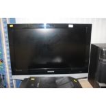 A Samsung flat screen TV with remote control