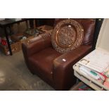 A brown leather upholstered armchair