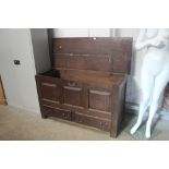 An oak panelled mule chest fitted two drawers