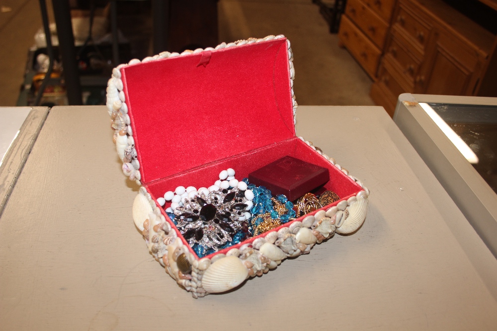 A shell encrusted jewellery box and contents of co