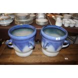 A pair of blue ceramic planters