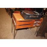 A small teak table raised on metal legs