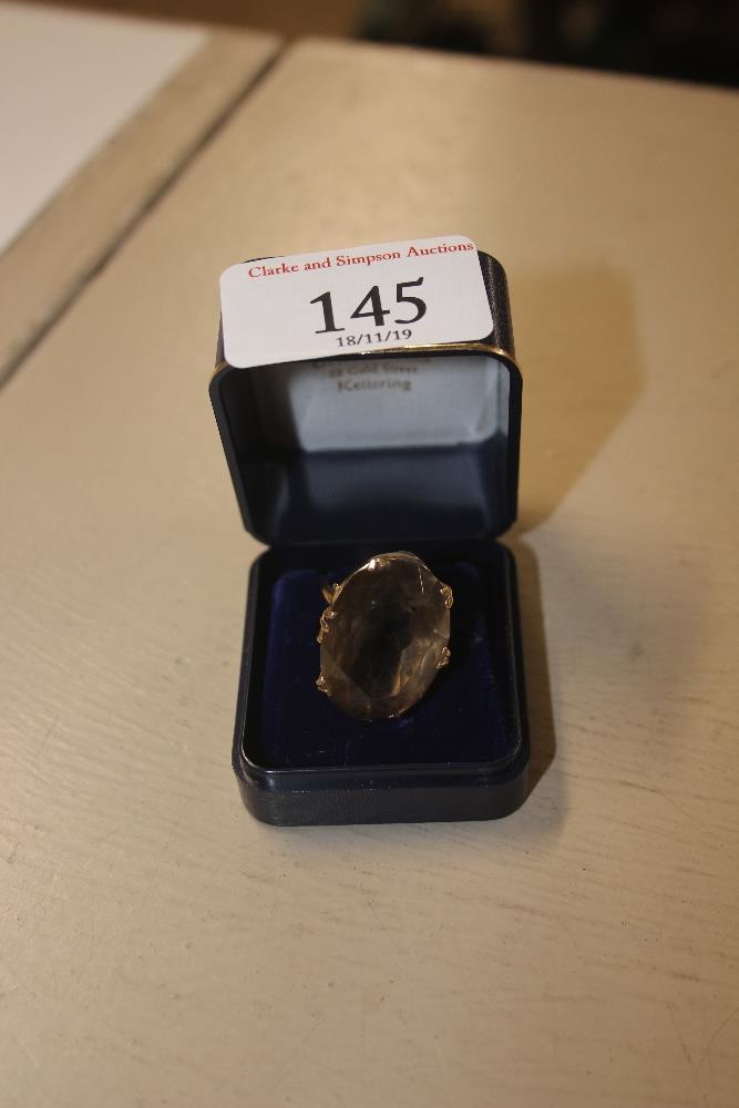 A 9ct gold ring set with a large smoky quartz styl