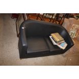 A faux leather tub shaped two seater sofa