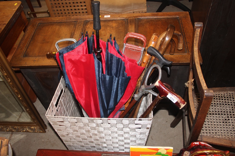 A basket of walking sticks, umbrellas and shooting