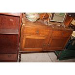 A 20th Century oak two drawer sideboard raised on