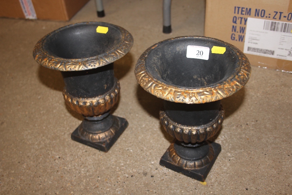 A pair of cast iron gilt decorated urns