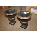 A pair of cast iron gilt decorated urns