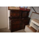 An Ercol court cupboard fitted two drawers