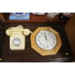A wall clock and a rotary dial telephone