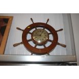 A clock decorated with a ships wheel