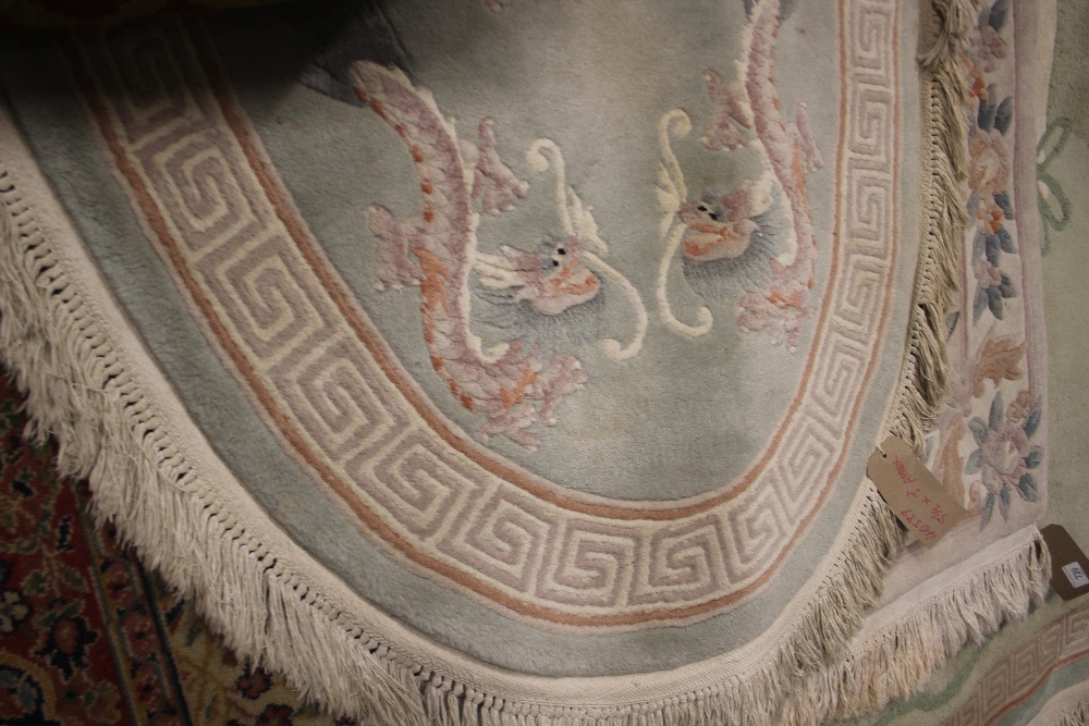 An approx. 5ft 6ins x 3ft oval Chinese wool rug