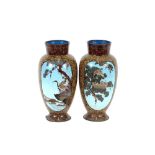 A pair of oriental cloisonne baluster vases, having panels decorated with cranes nesting, all over