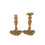 A pair of late 18th/early 19th Century French ormolu rococo candlesticks, of heavy gauge, in the