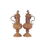 An imposing pair of copper Medieval style lidded flagons, surmounted by heraldic lion finials,