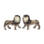 A pair of Staffordshire pottery lions, decorated in grey with manes and moulded bodies, 24cm