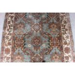 An oriental rug, having all over floral decoration on a celadon green and cream ground
