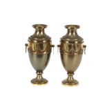A pair of lacquered metal urns, in the neo-classical taste, decorated with a band of garlands and