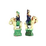 A pair of Chinese pottery studies of small elephants, being ridden by warriors, on naturalistic
