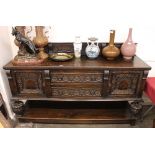 A carved oak sideboard, in the Jacobean manner, shallow back above two central drawers, flanked by