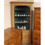 A 19th Century stripped pine standing corner cupboard, the upper painted section fitted shaped