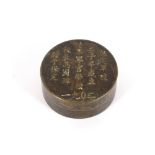 A circular Chinese bronze box, the lid decorated with calligraphy, 7.5cm dia.