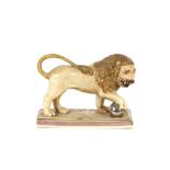 A 19th Century Staffordshire lion figure, right paw resting on a ball, 34cm long
