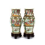 A pair of 19th Century Chinese Canton baluster vases, decorated with panels depicting interior