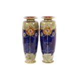 A pair of Doulton stoneware baluster vases, with Art Nouveau decoration on blue, green and brown