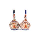 A pair of Imari onion shaped vases, decorated in the traditional manner, heightened in gilt, 35cm