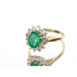 An 18 carat gold emerald and diamond set cluster ring